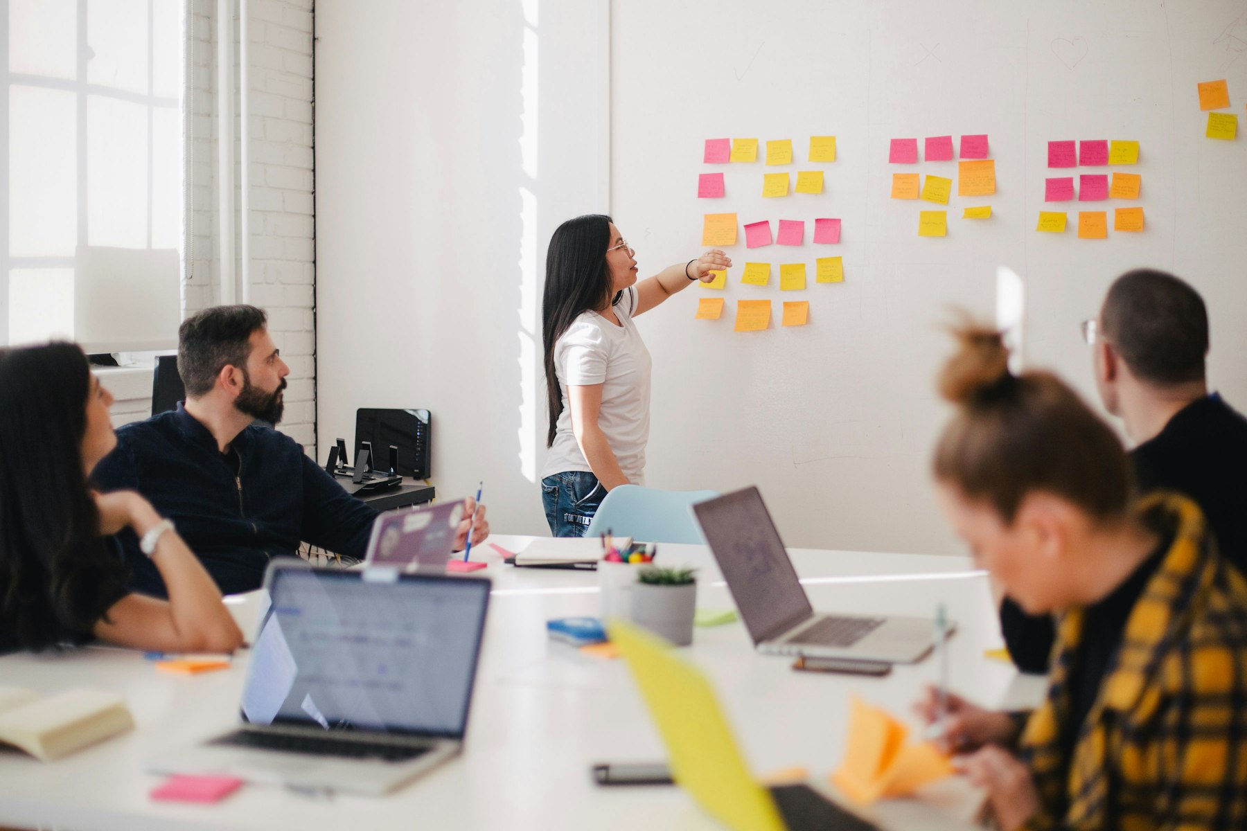 A media team reviewing channel notes, creative, and conversion paths on a studio wall